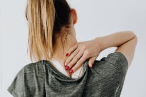 ragazza con dolori al colpo causati dal colpo di frusta